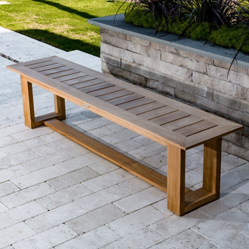 13909 Horizon teak 6 foot long Backless Bench on concrete stone patio with grass and garden in background