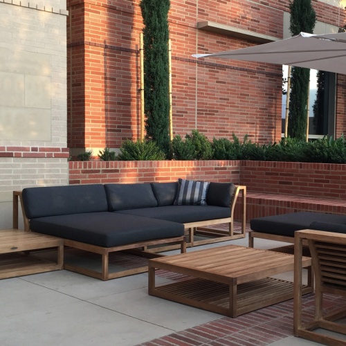 16800DP Maya teak chaise loungers with canvas colored cushions and throw pillows on the beach with ocean background at gurneys montauk yacht club resort