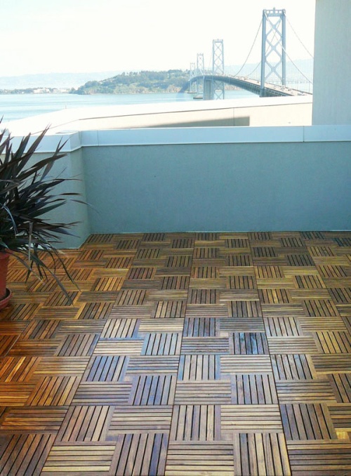  18412 parquet teak tiles assembled on a condo balcony with potted plant on teak floor bridge and land view in background
