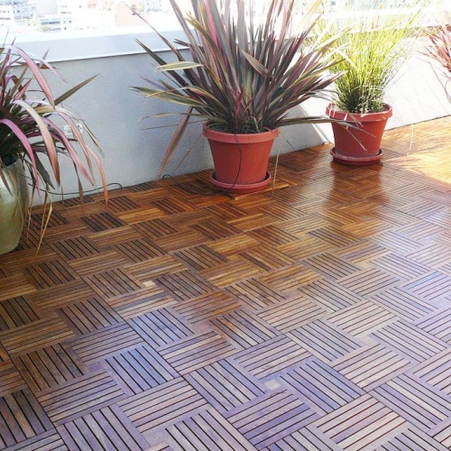 70402 parquet teak tiles twenty cartons covers two hundred five square feet on condo patio with four potted plants against balcony railing on floor with buildings in background