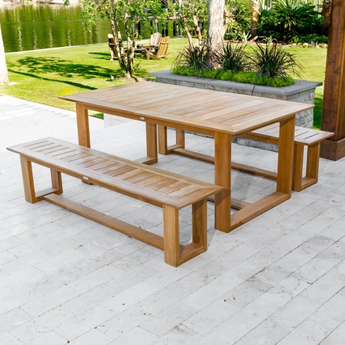 70497 Horizon teak Picnic Dining Set on outdoor patio with paver planters and plants with grass area shrubs and lake in background