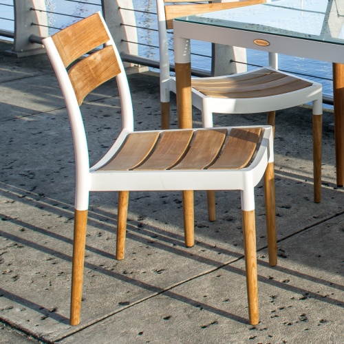 70556 Bloom teak and powder coated aluminum side chair angled side view on boat dock overlooking boat marina in background