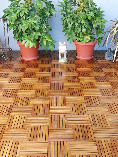 18412 parquet teak tiles assembled on a condo deck with 2 potted plants against wall in background