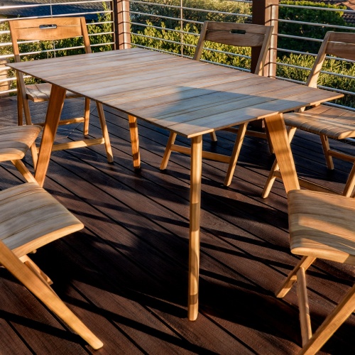 70518 Surf teak 7 piece folding Dining Set on wood deck close up view with natural vegetation in background