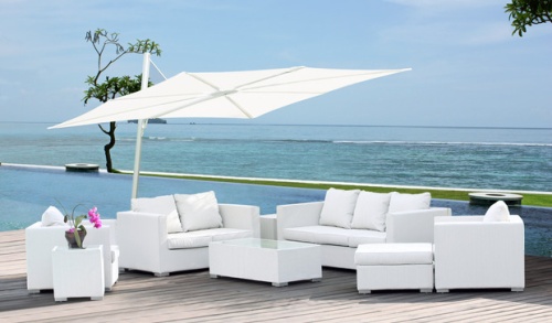 sps25100ffb spectra solo umbrella only on terrace over deep seating set flowering orchid plant  with pool grass area ocean and blue sky in background