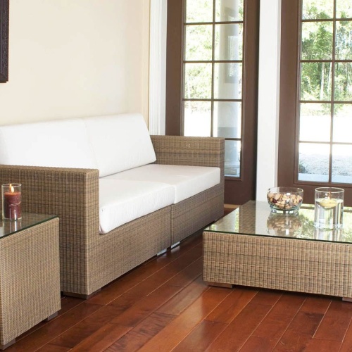 70241 Malaga cushioned Woven Wicker Sofa Set interior location on wood floors with two lit pillar candles bowl mixed nuts floating candle on glass top tables with windows of outside view