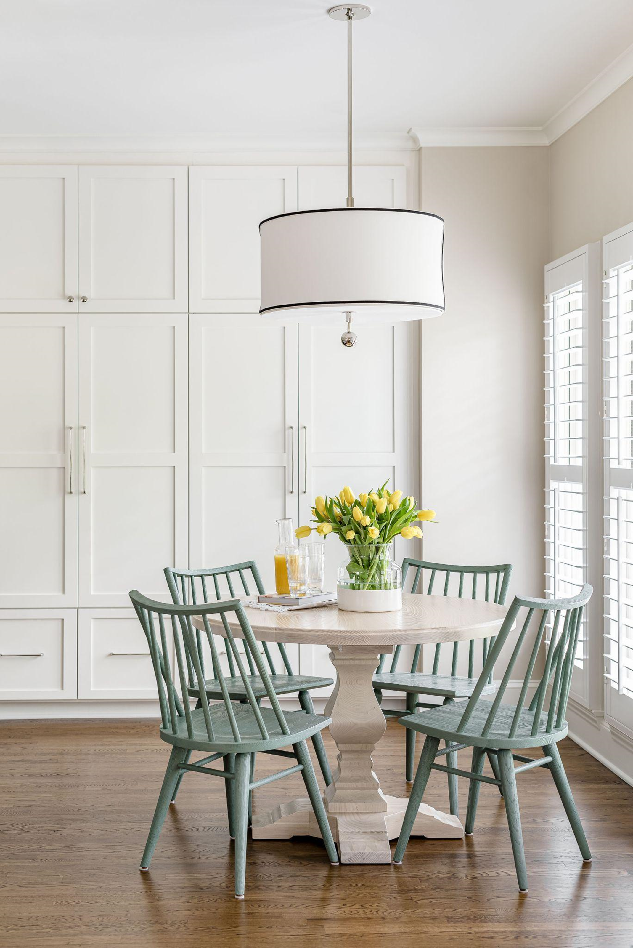 White round pedestal table with 4 stone green dining chairs