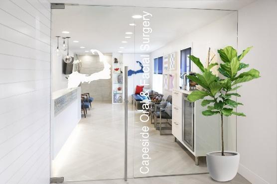 An image of a medical office entry way with a potted Fig tree next to the door to the reception area in the background.