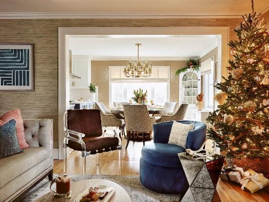 An image of  a  living room featuring a Christmas tree with a dining room in the background.